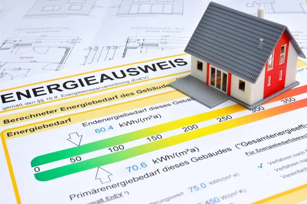 Gebäudeenergieausweis mit Energieeffizienzklassen neben einem modernen Wohnhaus