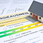 Gebäudeenergieausweis mit Energieeffizienzklassen neben einem modernen Wohnhaus