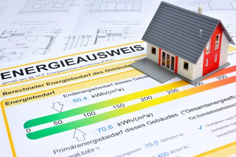 Gebäudeenergieausweis mit Energieeffizienzklassen neben einem modernen Wohnhaus